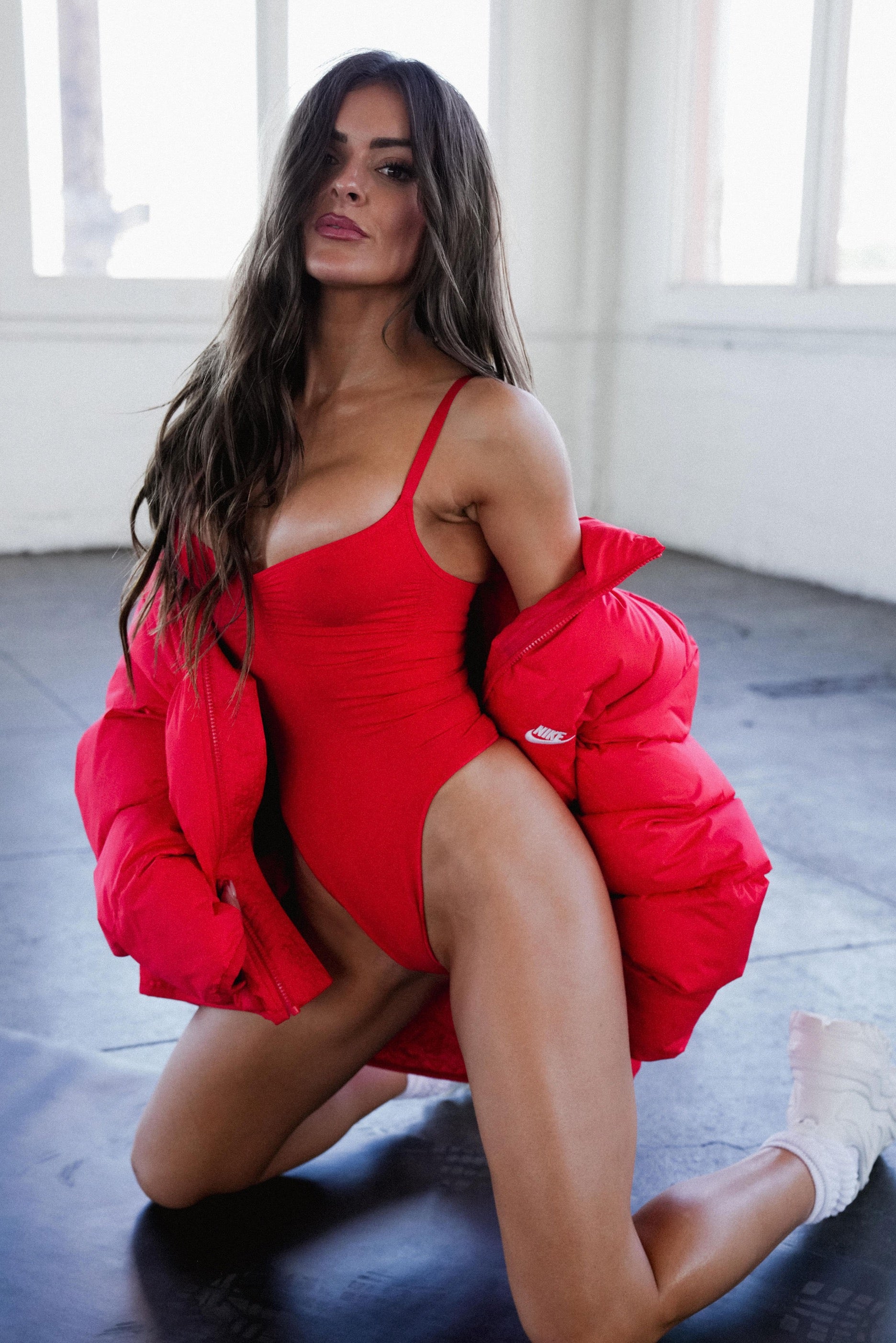 Nicole in red leotard on knees with red puffer off the shoulders